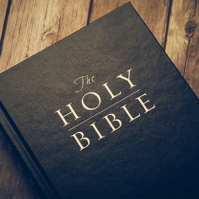 Black leather Holy Bible on wooden table